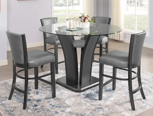 A dining room table with four chairs and a rug.