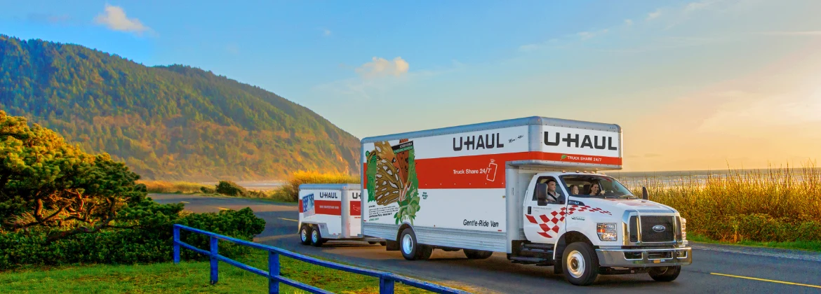 A u-haul truck is driving down the road.