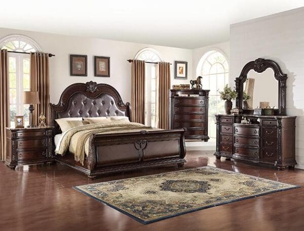 A bedroom with a bed, dresser and night stand.